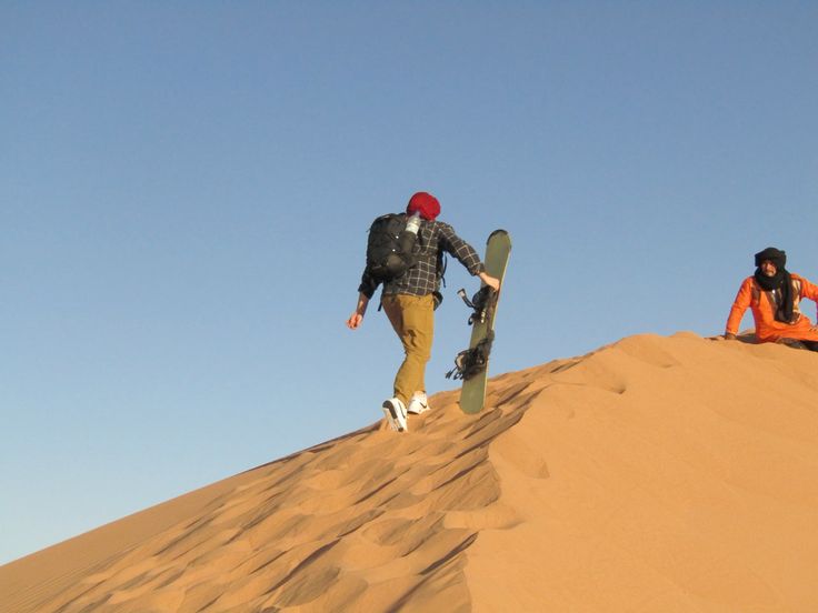 Kids sandboarding during a Dubai desert camp adventure