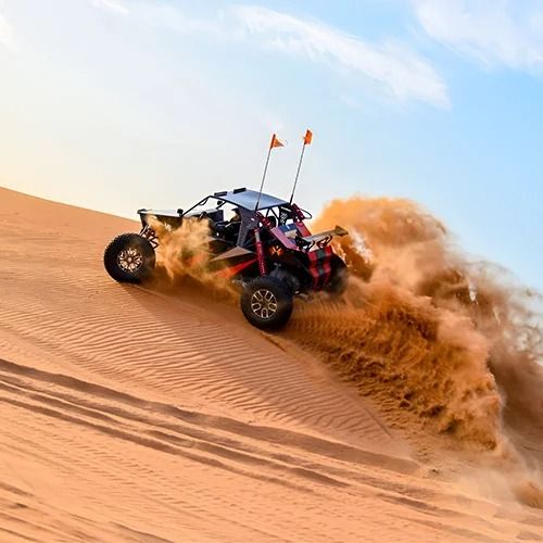 Quad bike and ATV wheels kicking up sand in Dubai desert